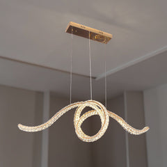 Qulik luxury crystal chandelier in French Gold with sculptural looping LED arms and suspended rectangular ceiling mount.
