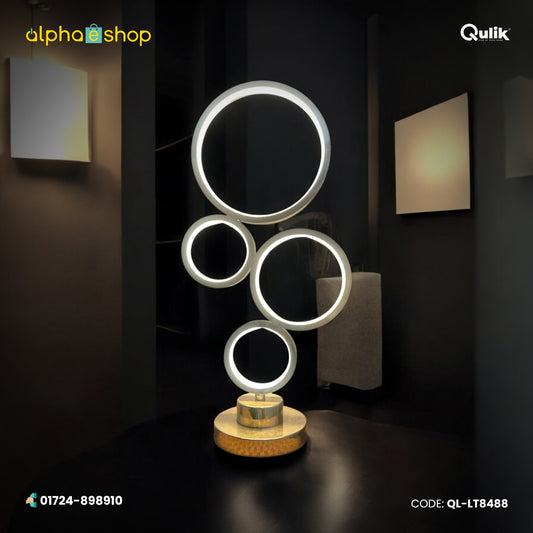 Qulik Lunar Rings LED table lamp with four illuminated circular rings, gold-tone base and modern decorative design.
